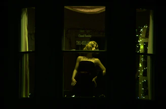 A stylish mannequin dressed in a flowing silk evening gown under warm lighting