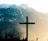 brown cross on brown tree near snow covered mountain during daytime