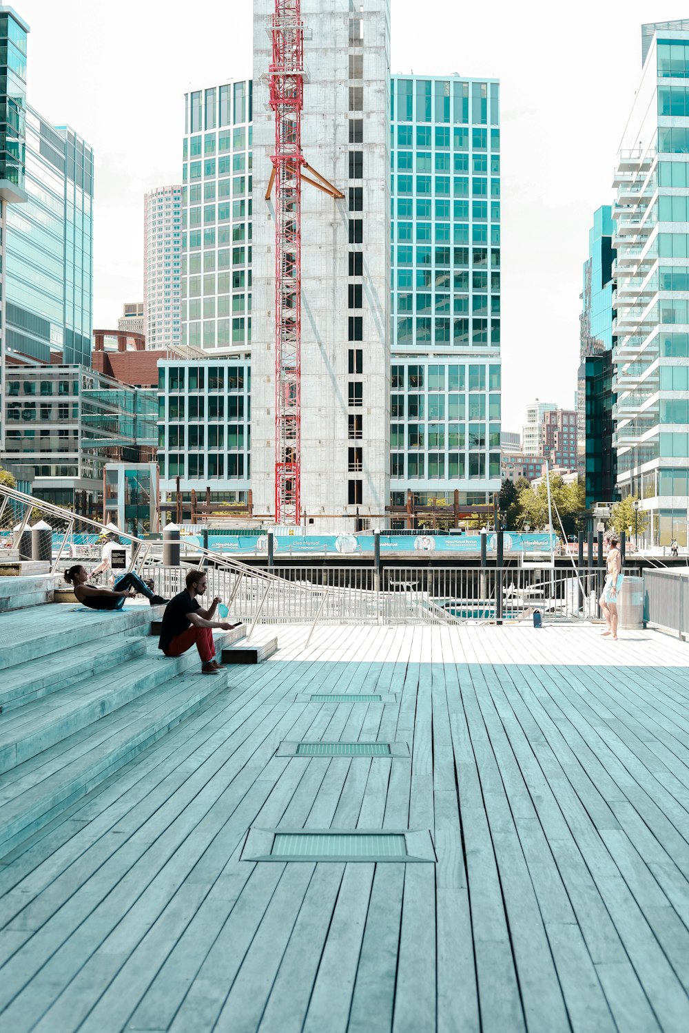 man in black jacket sitting on bench near building during daytime