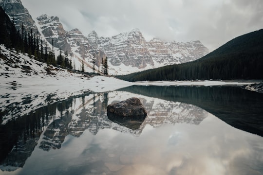 brown and white mountain near body of water during daytime in Banff National Park Canada