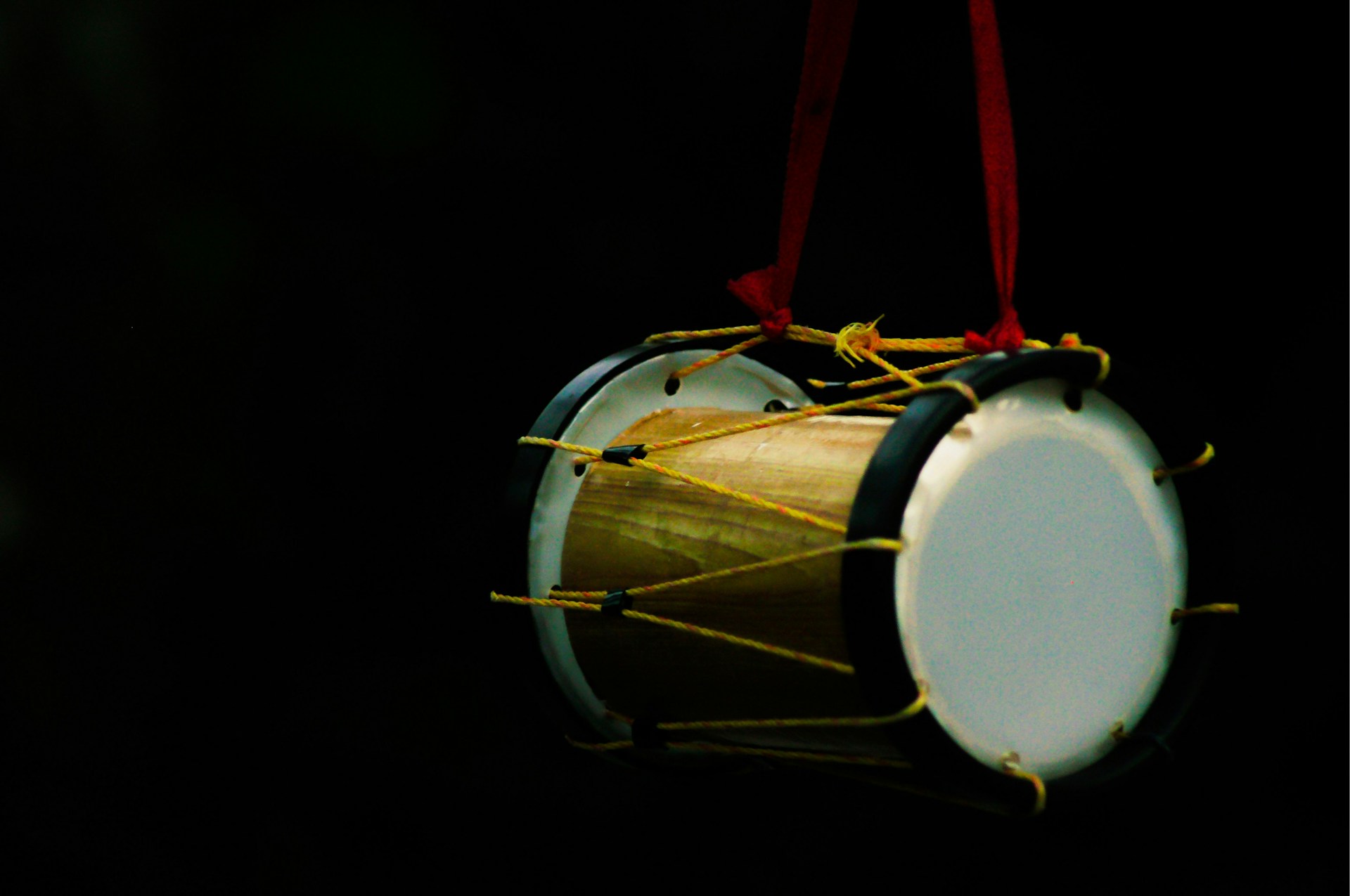 white and brown drum with red strap