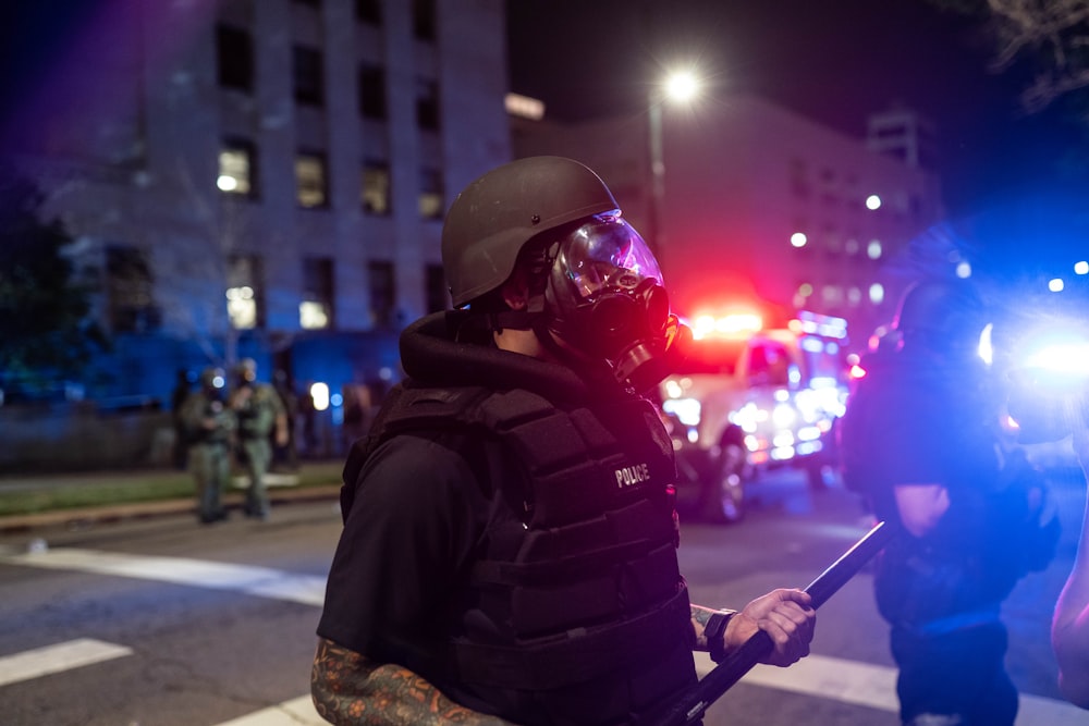 man in black jacket wearing red helmet holding a stick