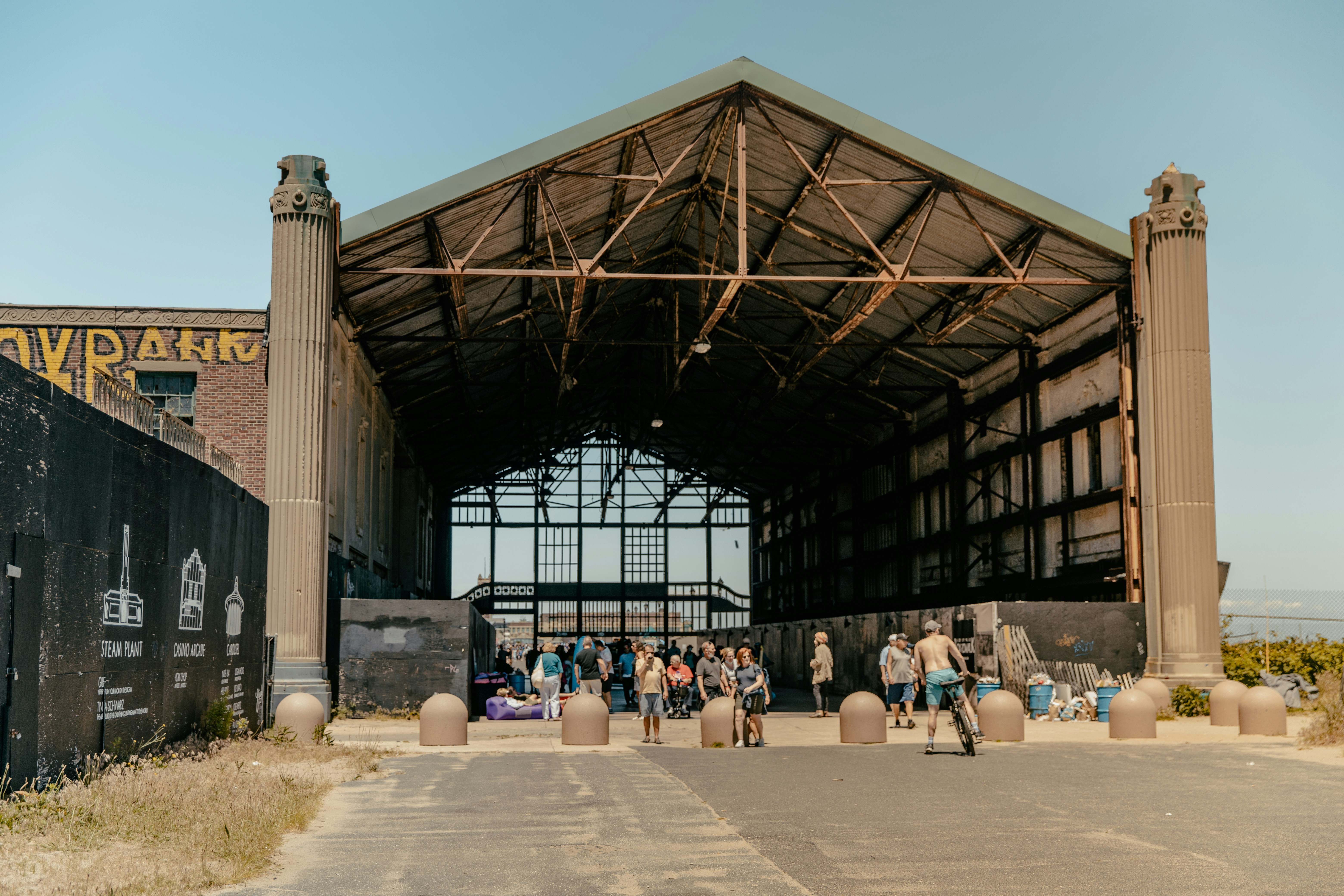 people sitting on bench under brown wooden roof during daytime