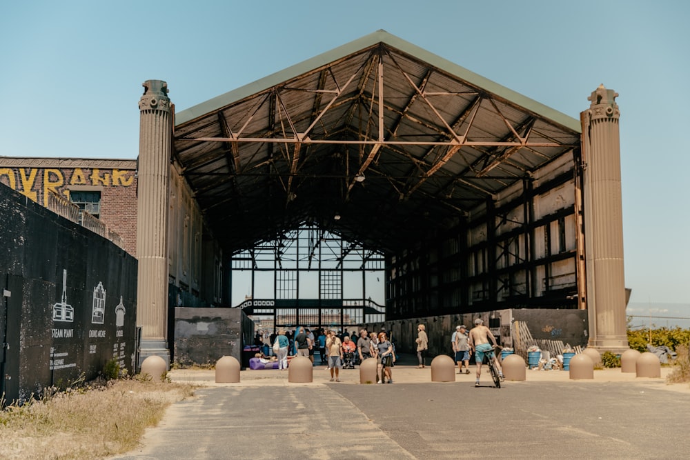 people sitting on bench under brown wooden roof during daytime