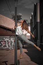 woman in white long sleeve shirt and gray pants standing on gray concrete road during daytime