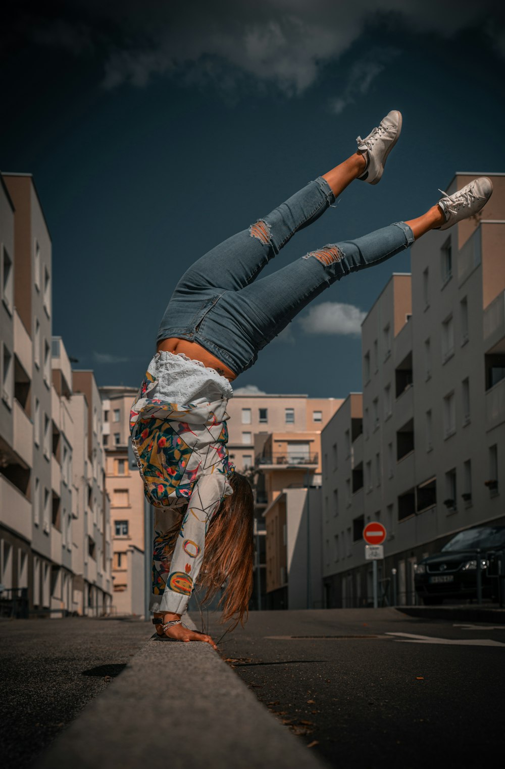 woman in blue denim jeans and brown and white scarf standing on brown concrete building during