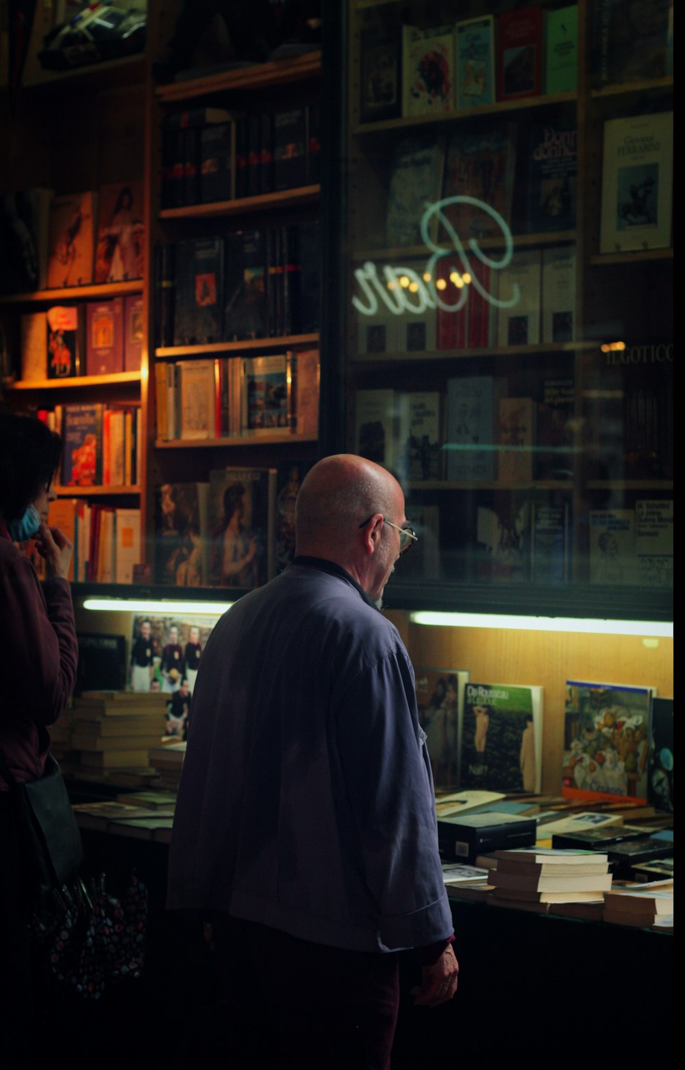 man in black suit standing in front of store