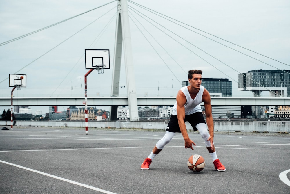 man in black tank top running on road during daytime