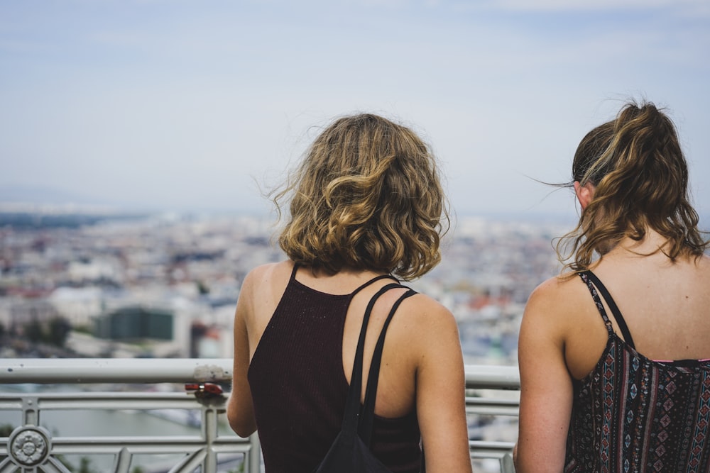 woman in black tank top standing beside railings during daytime