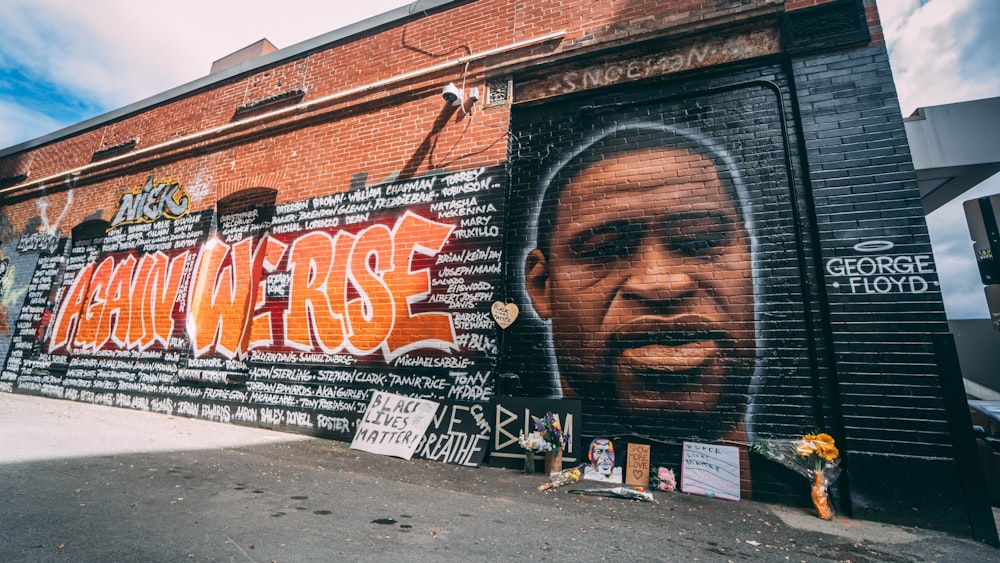 Mann im schwarzen Hemd steht an der Wand mit Graffiti