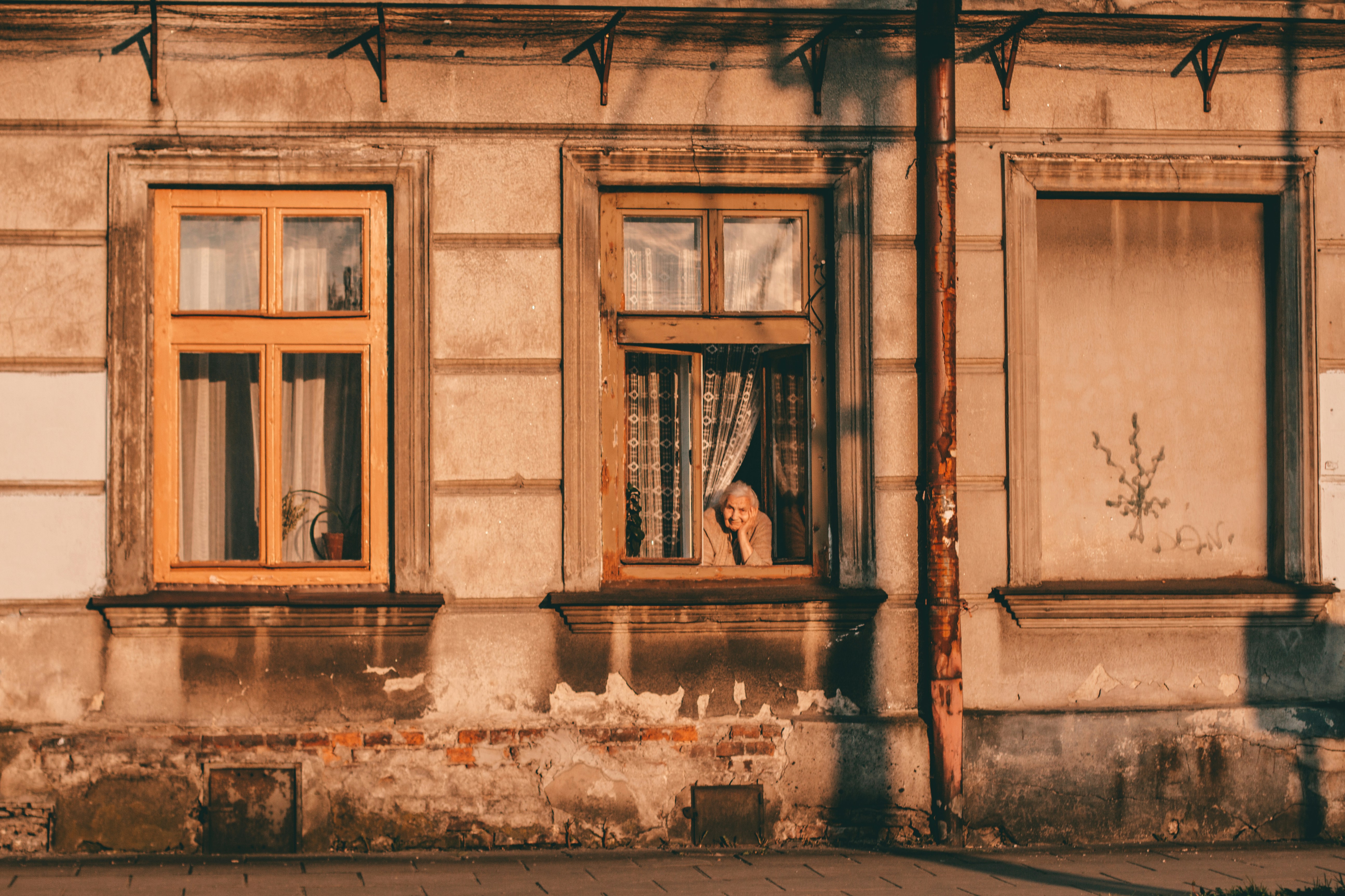 a woman looking out of a window of an old building