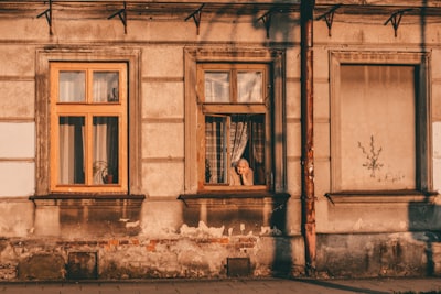 a woman looking out of a window of an old building