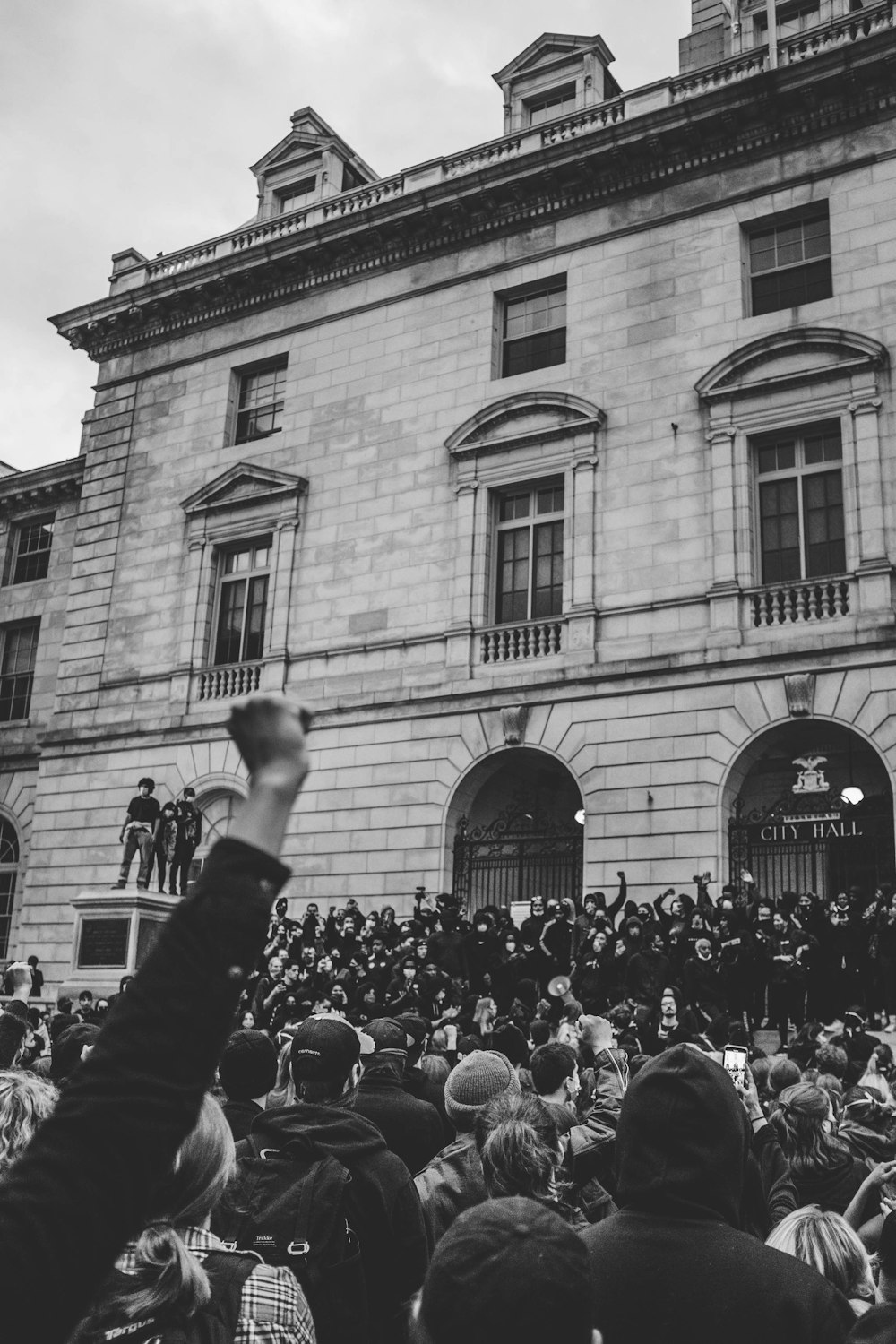 grayscale photo of people in front of building