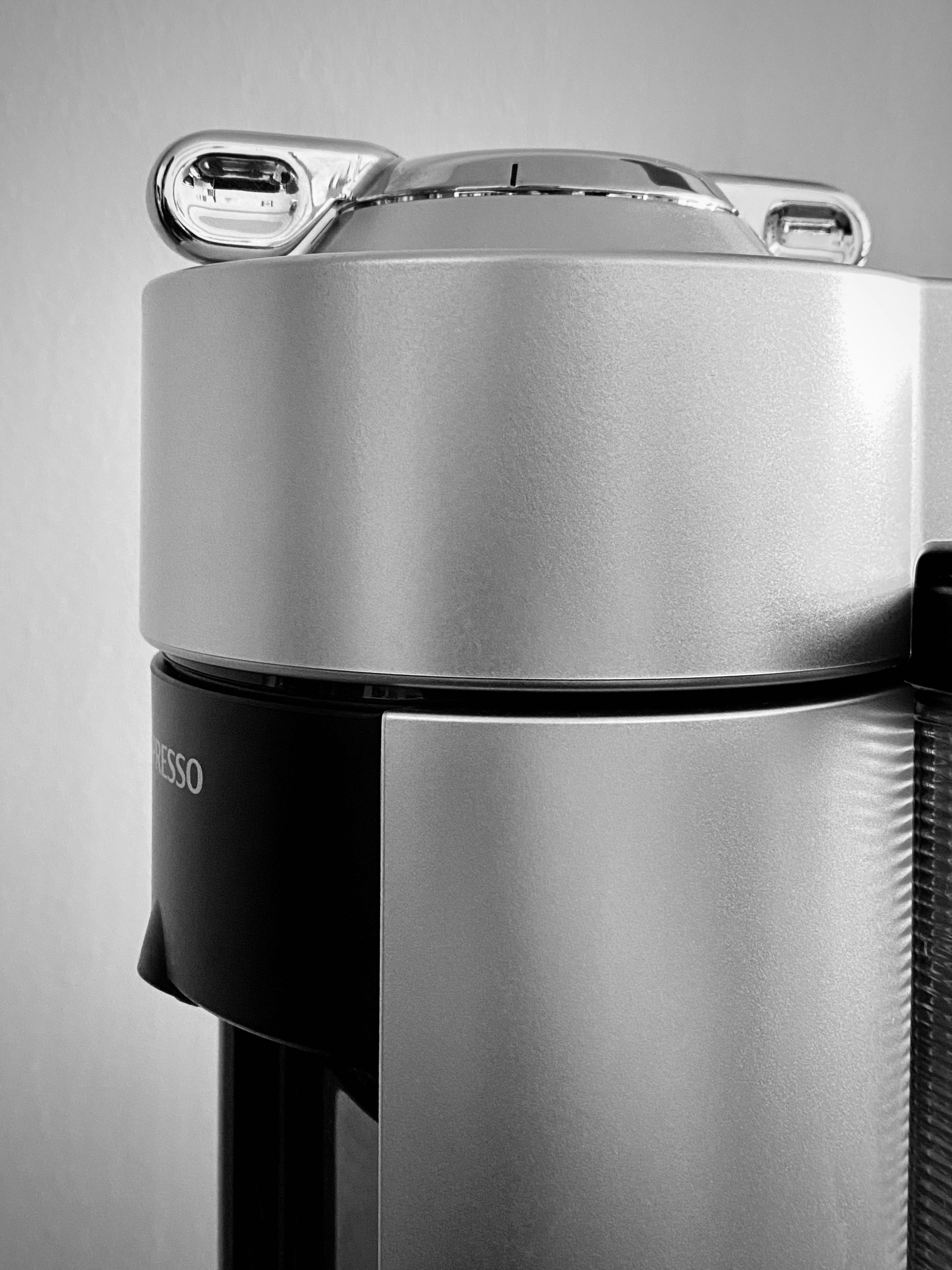 Sleek silver Nespresso coffee machine on white kitchen counter with coffee pods