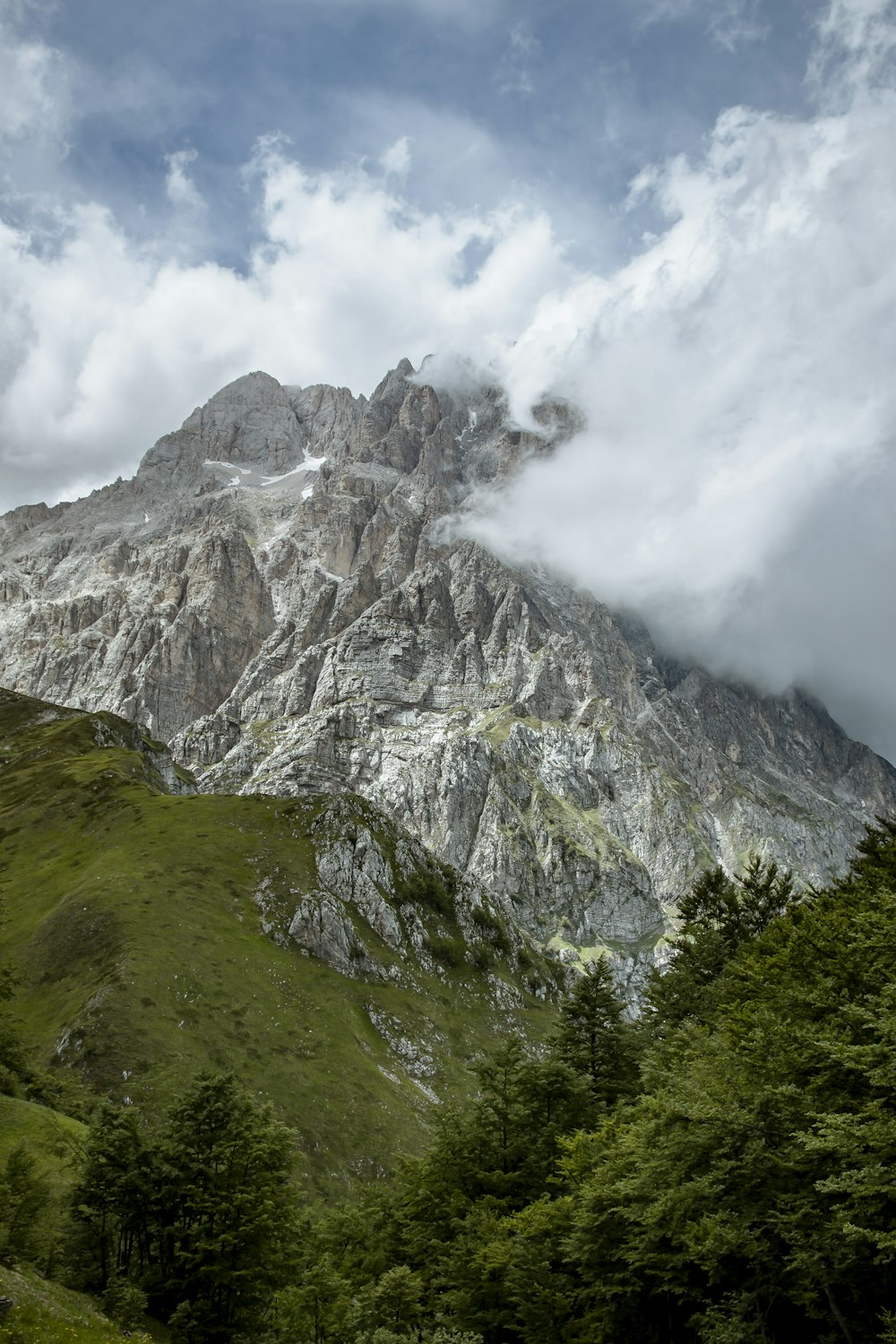 green and gray mountain under white clouds during daytime