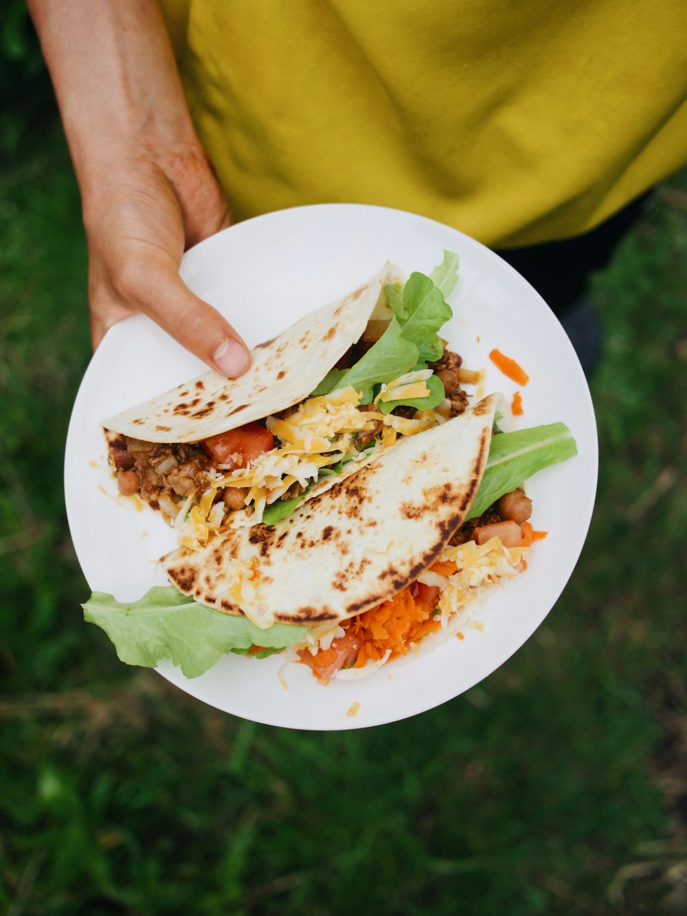 person holding white ceramic plate with food