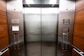 Close-up shot of skilled hands assembling a sleek elevator panel with metallic accents.