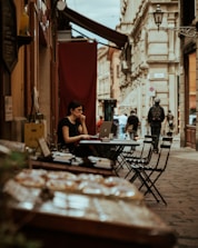 A traveler using a laptop outdoors, accessing their mail from a café.