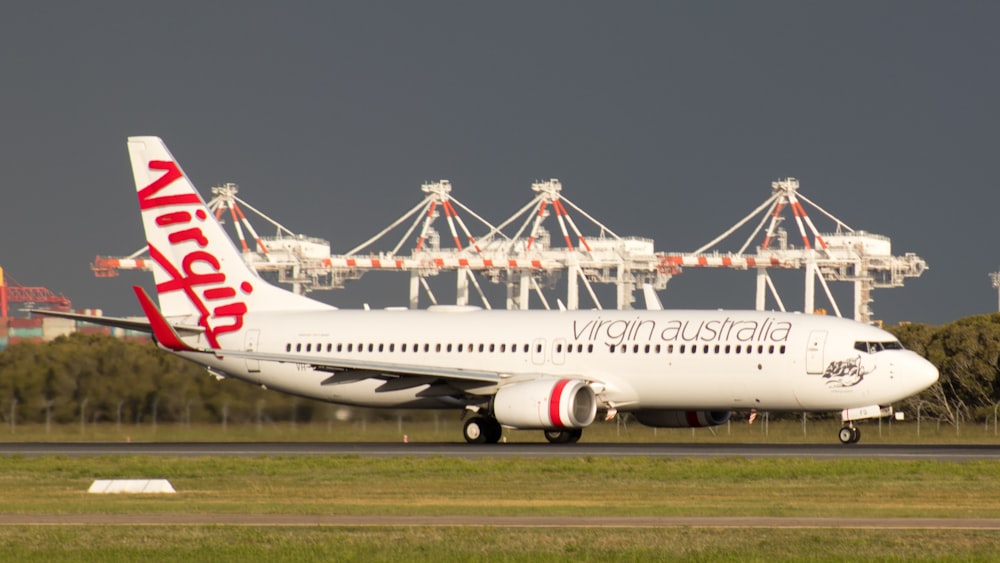 white and red passenger plane on airport during daytime