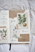 A journal spread features botanical illustrations and handwritten words. The left side displays a drawing of flowers and leaves, while the right side contains images of a sweet orange and lavender. Words like 'faith,' 'hope,' and 'love' are thoughtfully written around the illustrations. The page has a textured and artistic feel with the use of tape and torn paper.