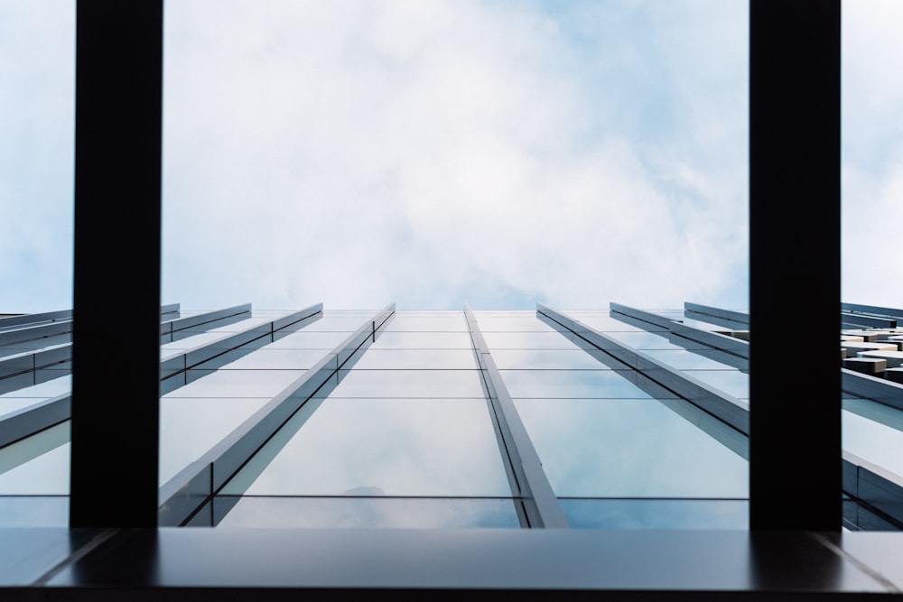 low angle photography of gray metal frame under white clouds during daytime