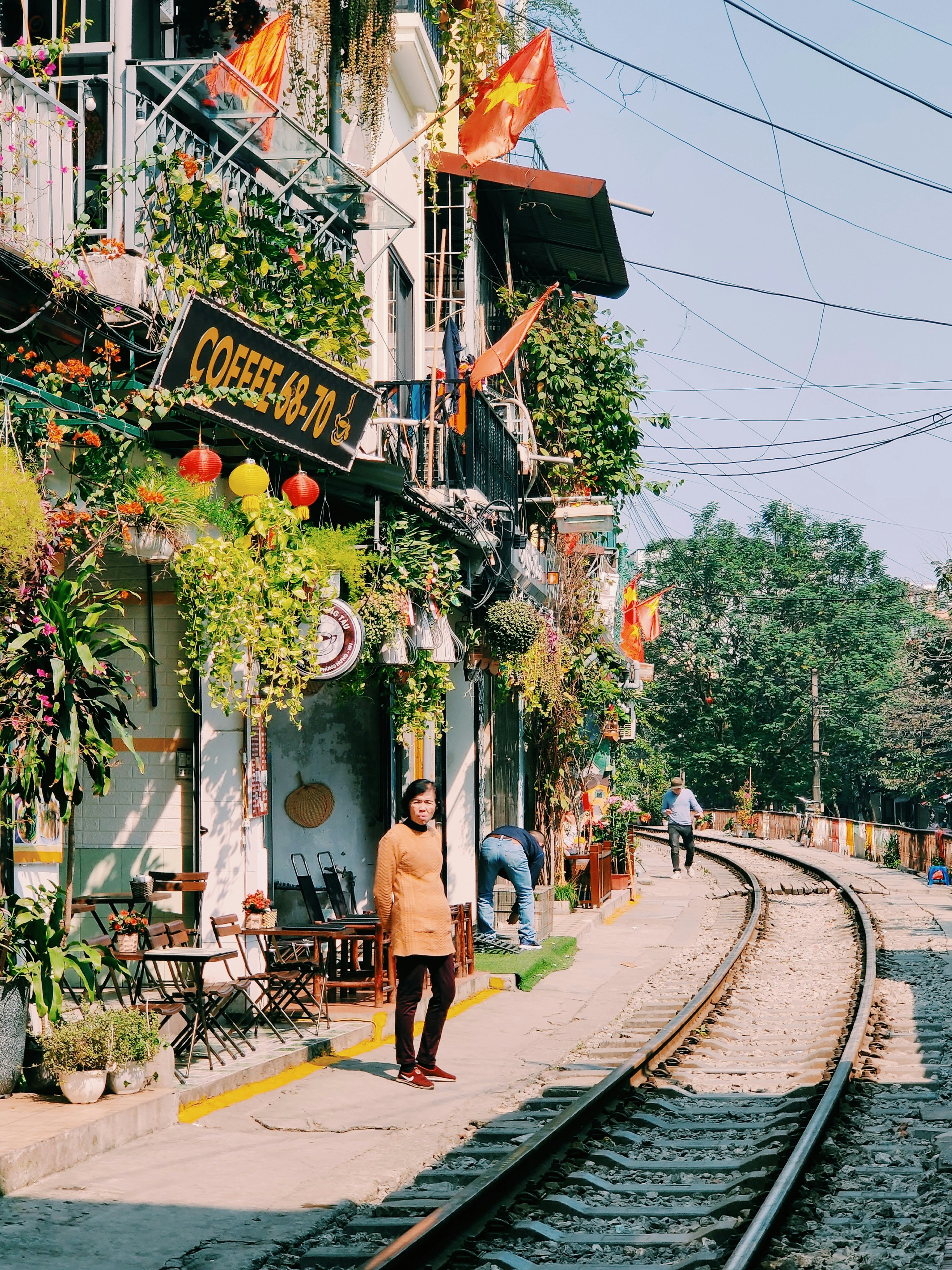Personas que caminan por la acera cerca de árboles y edificios durante el día