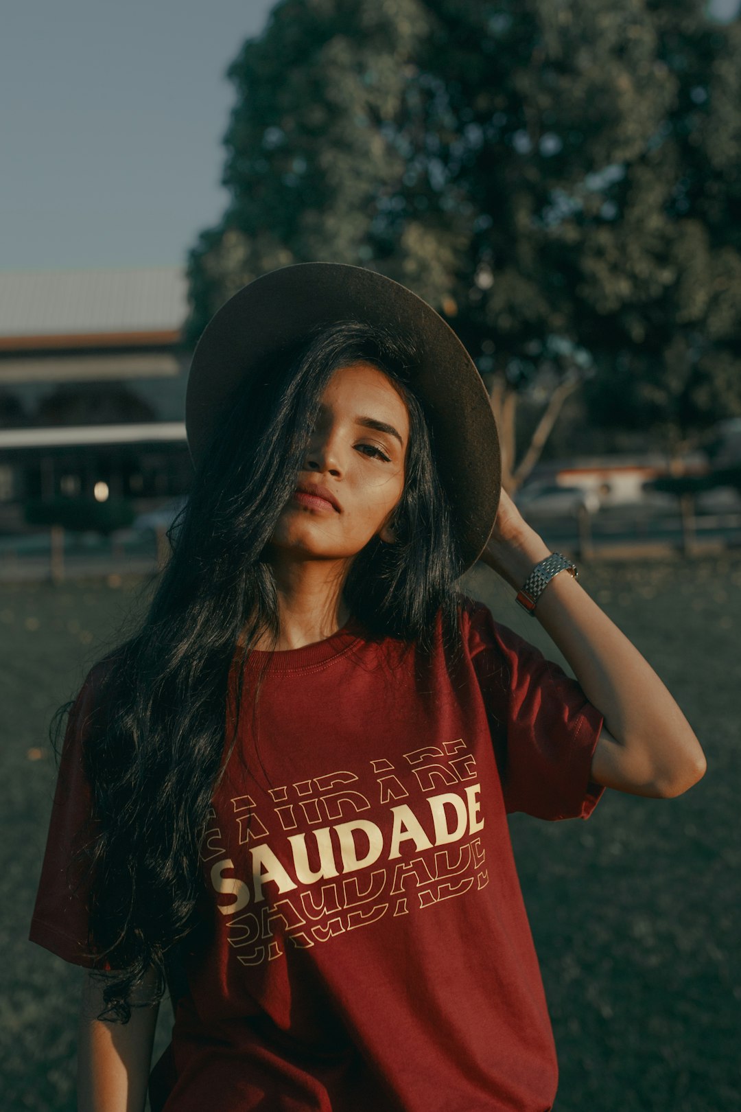 woman in red and white crew neck t-shirt wearing black fedora hat