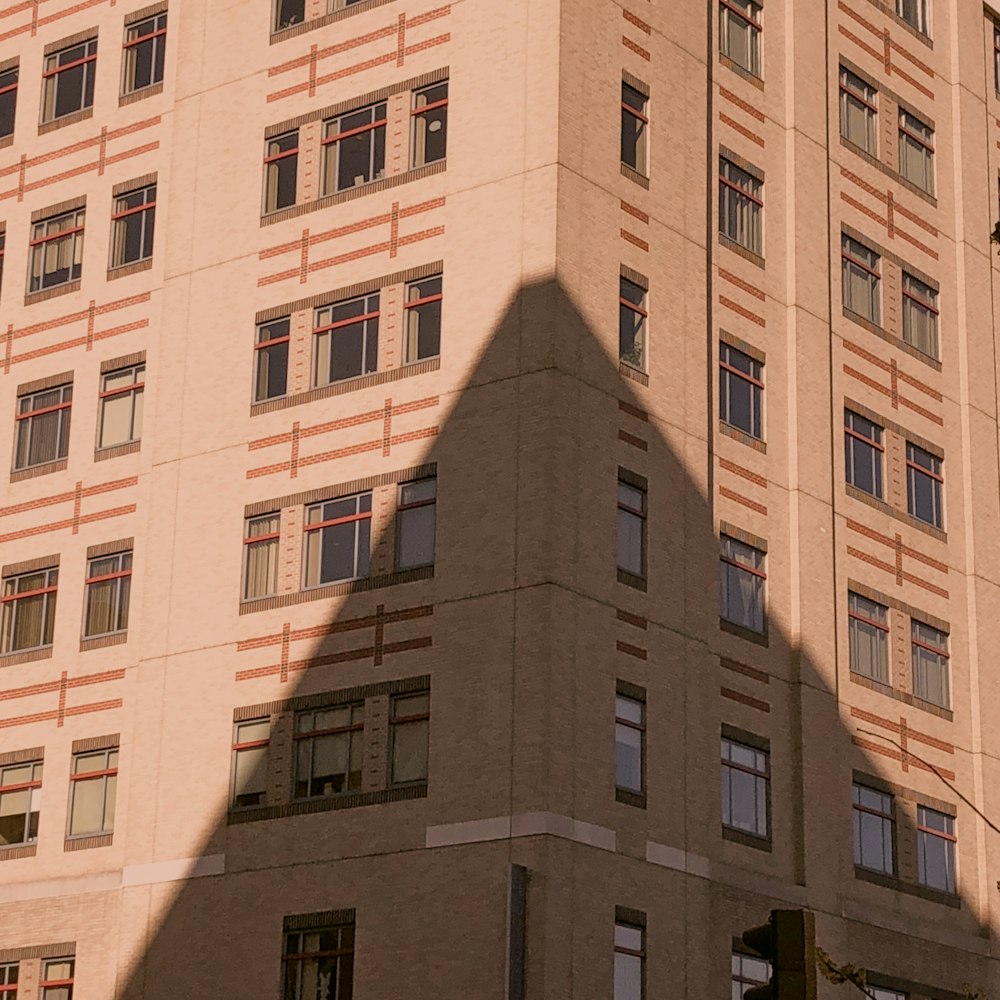 a shadow of a building on the side of a street