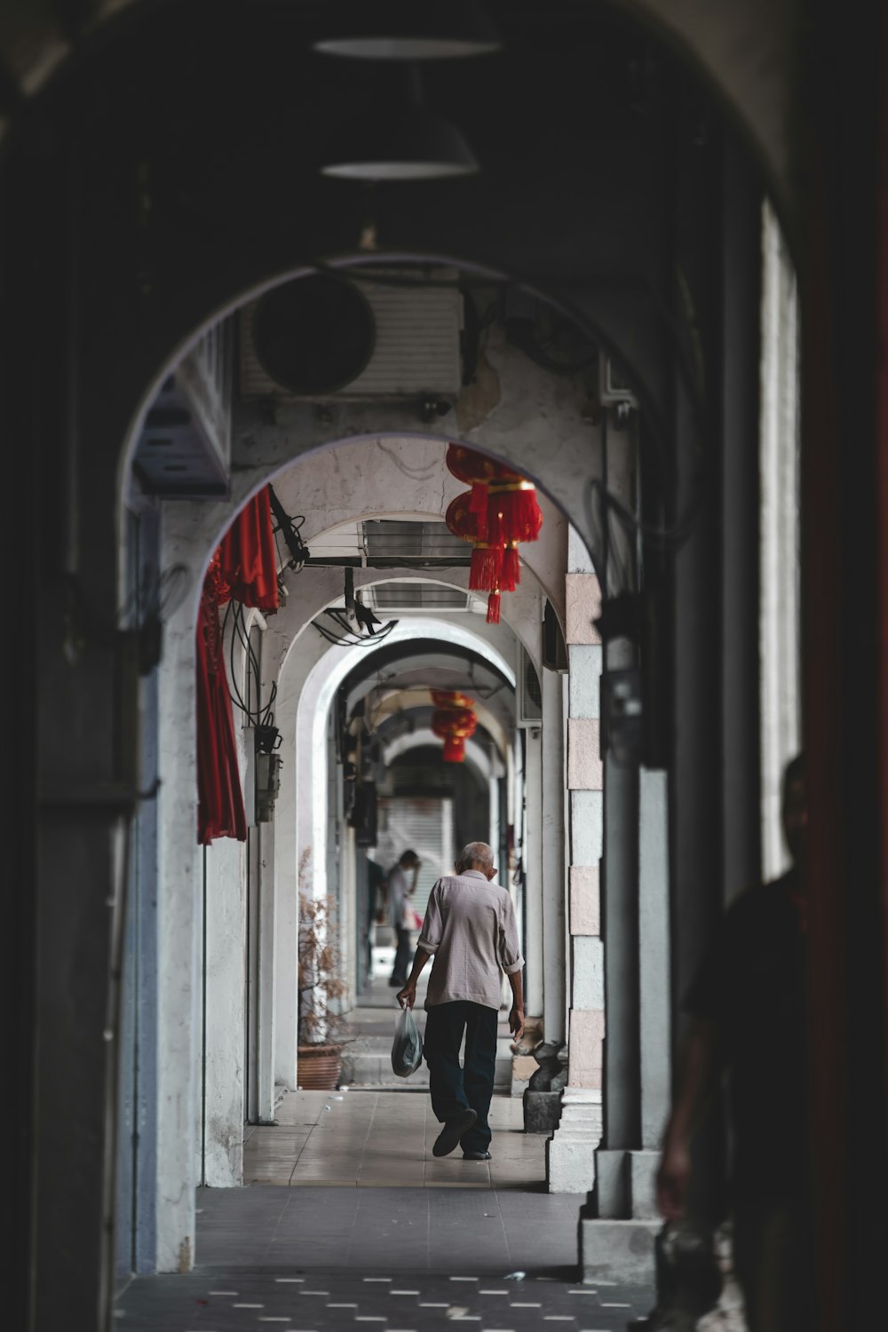 woman in white shirt and black pants walking on hallway