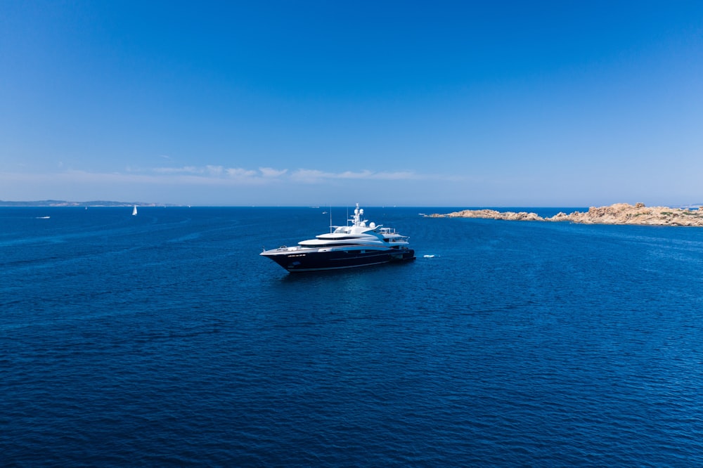 white and black yacht on sea under blue sky during daytime