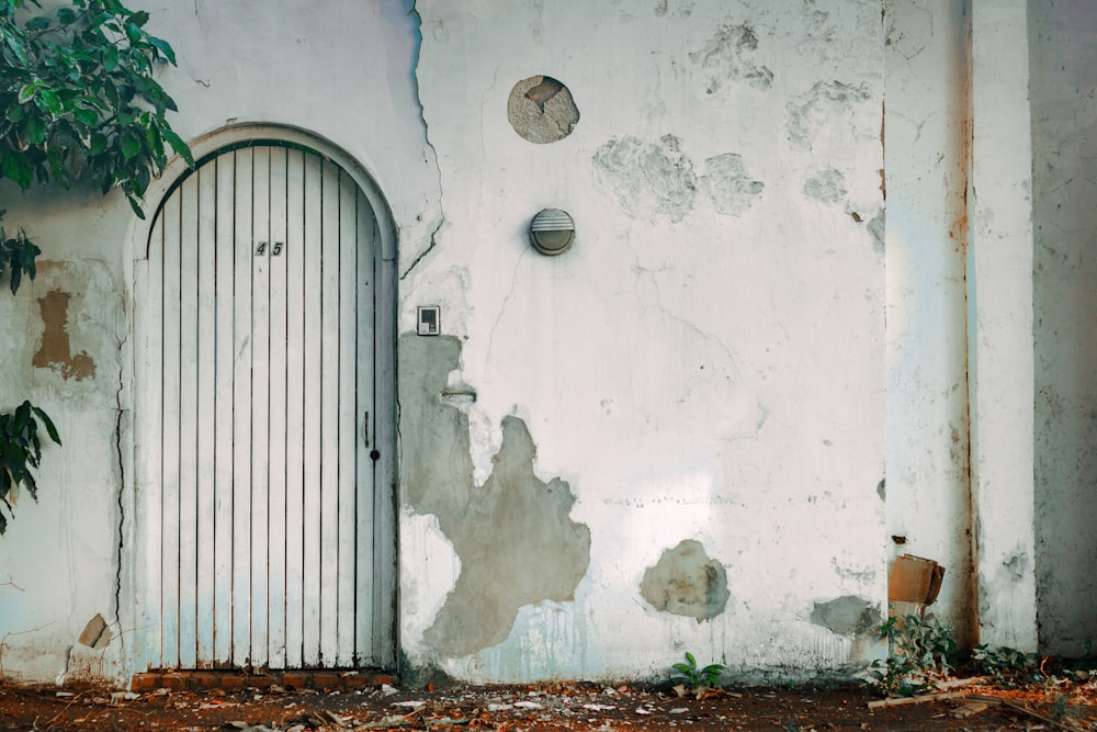 white wooden door on white concrete wall