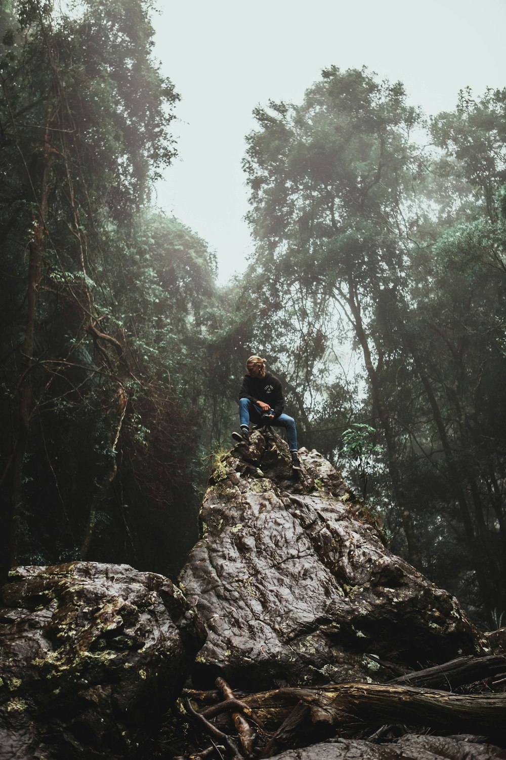 man in blue jacket climbing on brown rocky mountain during daytime