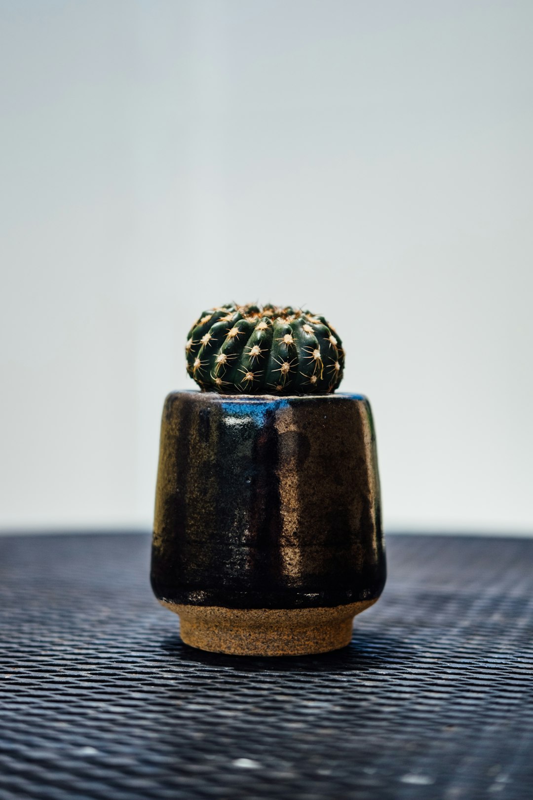 brown and green ceramic jar on brown wooden table