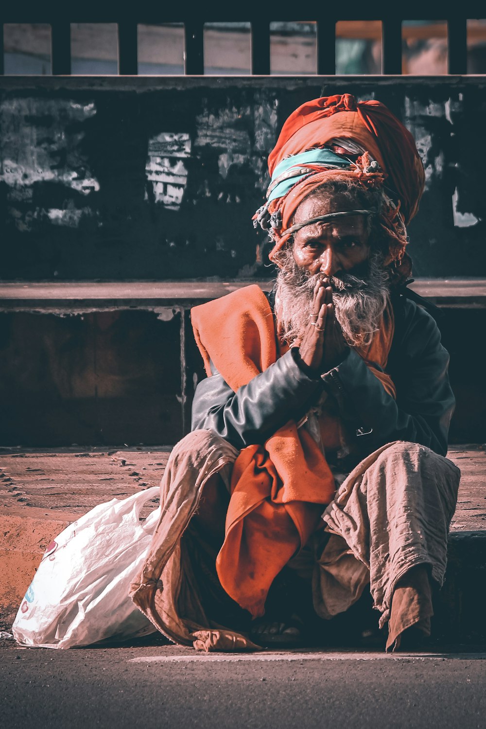 man in brown thobe sitting on ground