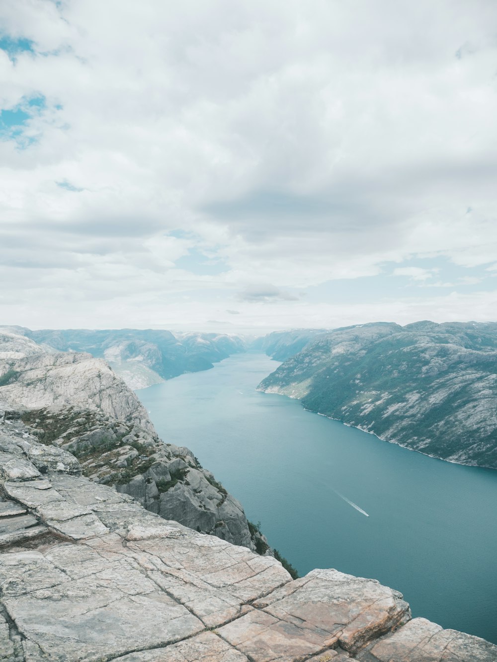 lac entre les montagnes sous ciel nuageux pendant la journée