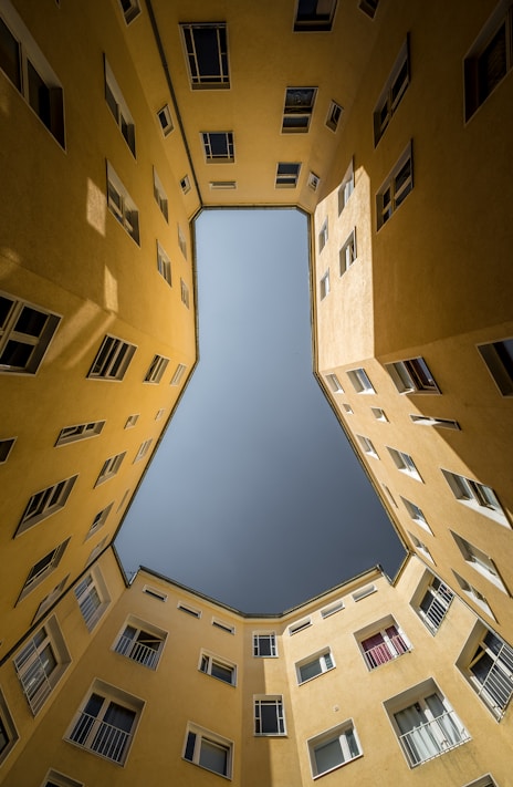 low angle photography of brown concrete building under blue sky during daytime