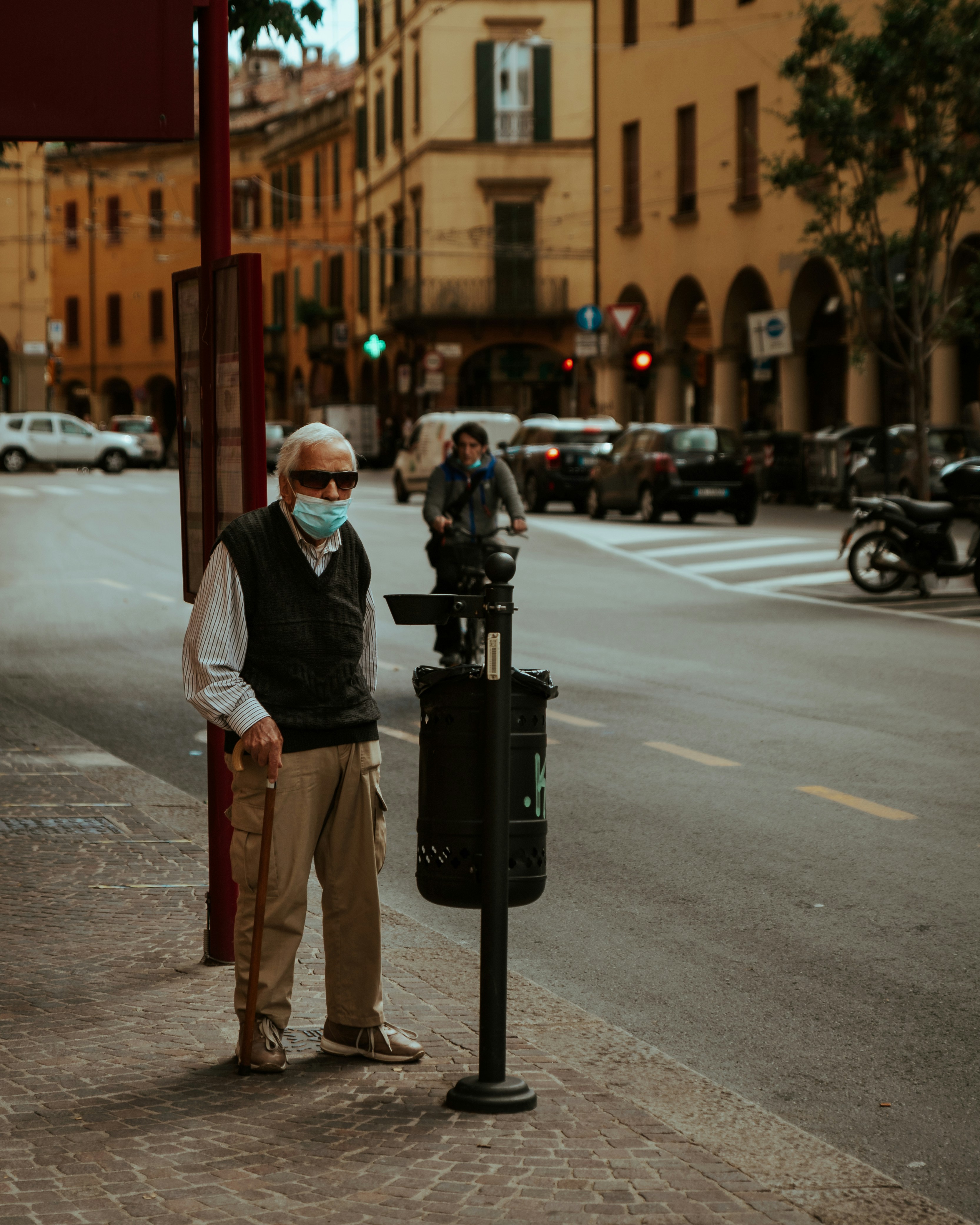 man in white dress shirt and brown pants standing on sidewalk during daytime