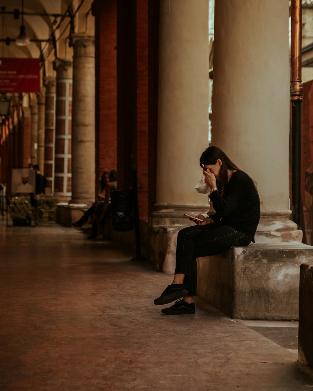 man in black jacket sitting on bench