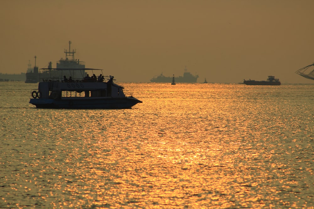 silhouette of boat on sea during sunset