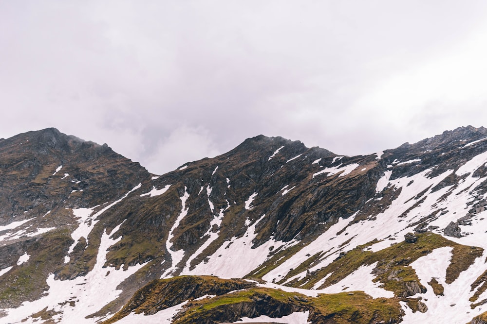 snow covered mountain under cloudy sky during daytime