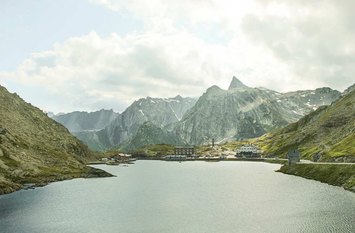 The lake at the Great St Bernard pass, with the hospice buildings and grey peaks behind