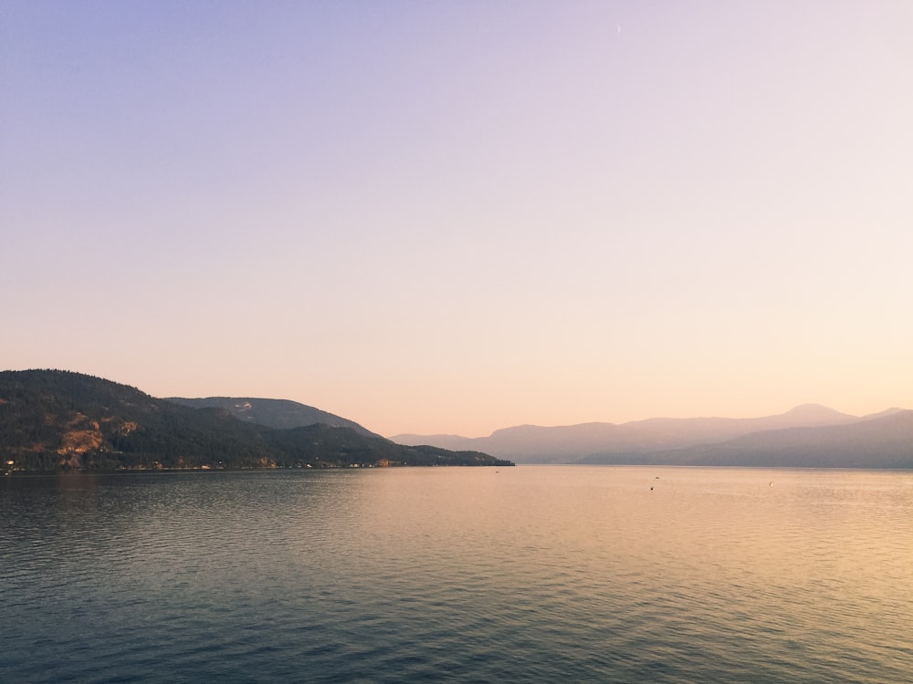 corpo d'acqua vicino alla montagna durante il giorno