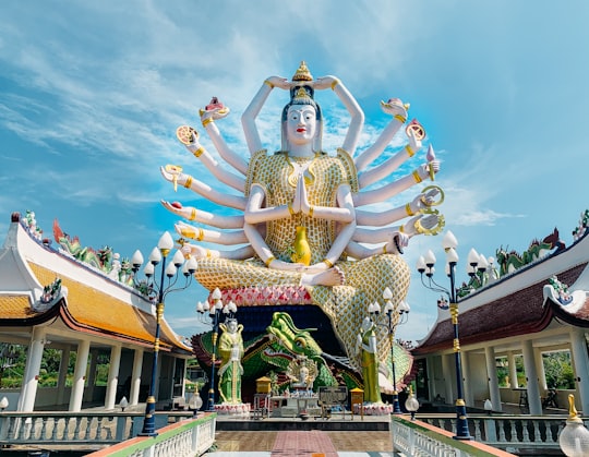gold and blue hindu deity statue in Wat Plai Laem Thailand