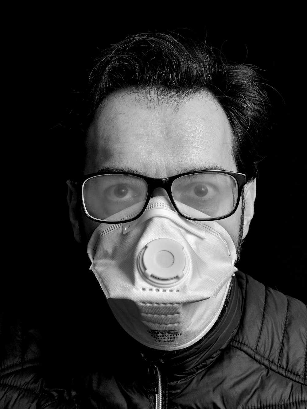 Foto en escala de grises de una persona con máscara para los ojos