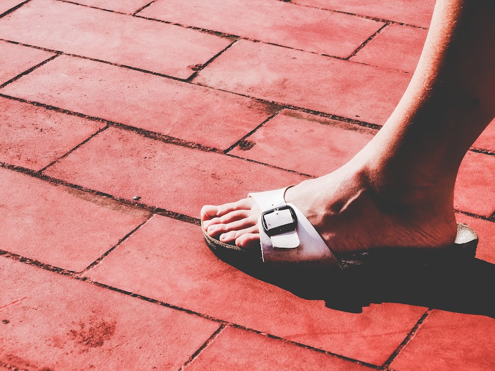 person wearing white and black flip flop