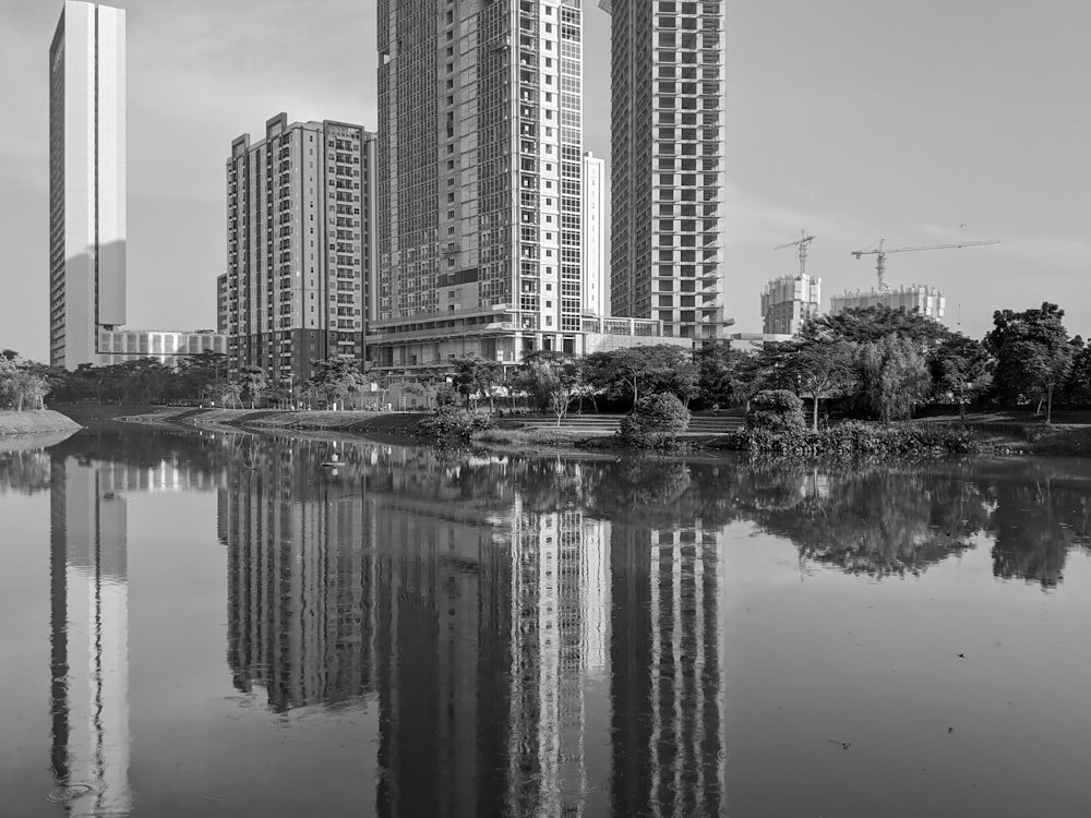 grayscale photo of high rise buildings near body of water