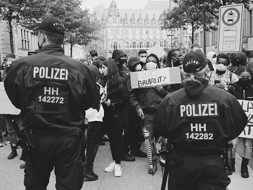 Un groupe de policiers debout devant une foule de personnes