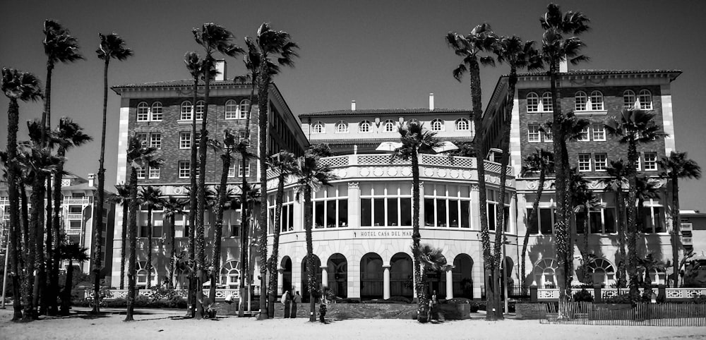 grayscale photo of building near trees