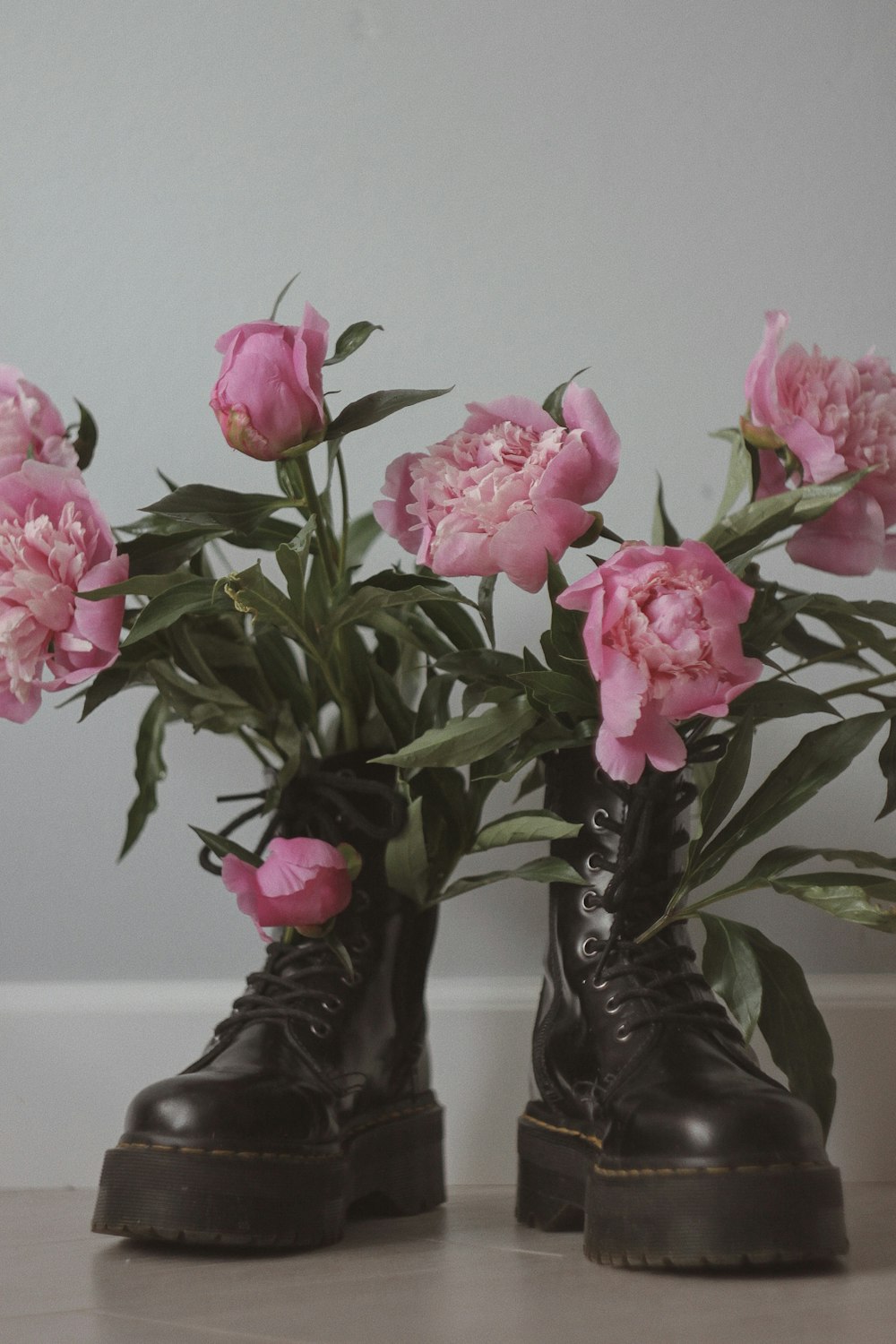 rosas cor-de-rosa em botas de chuva pretas