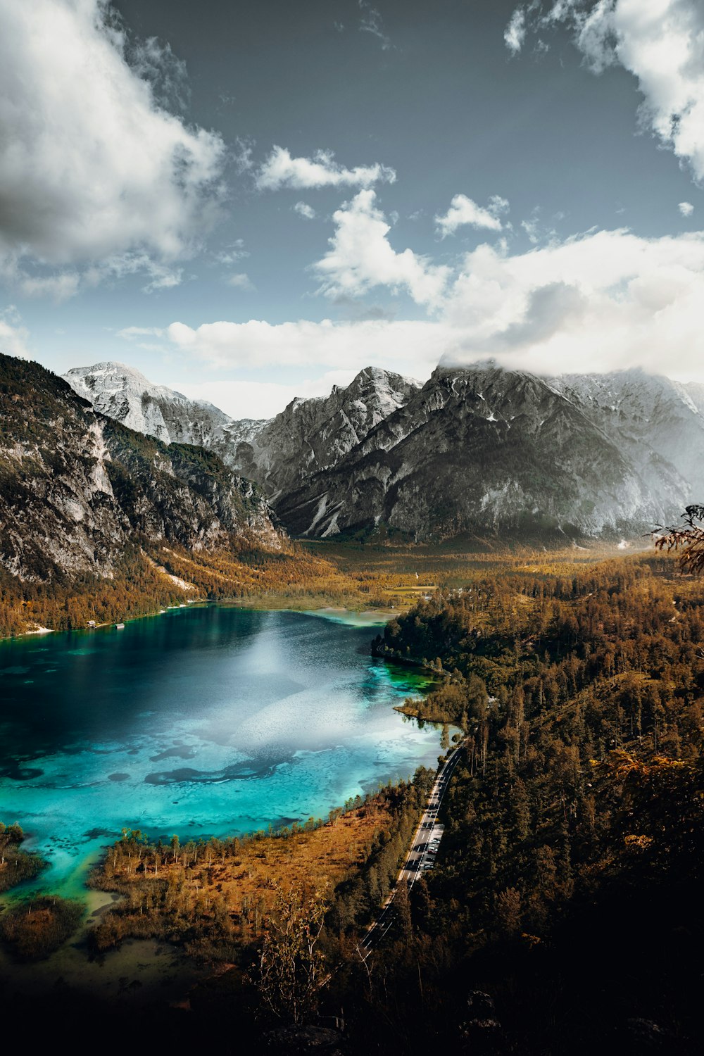 lago no meio das montanhas sob nuvens brancas e céu azul durante o dia